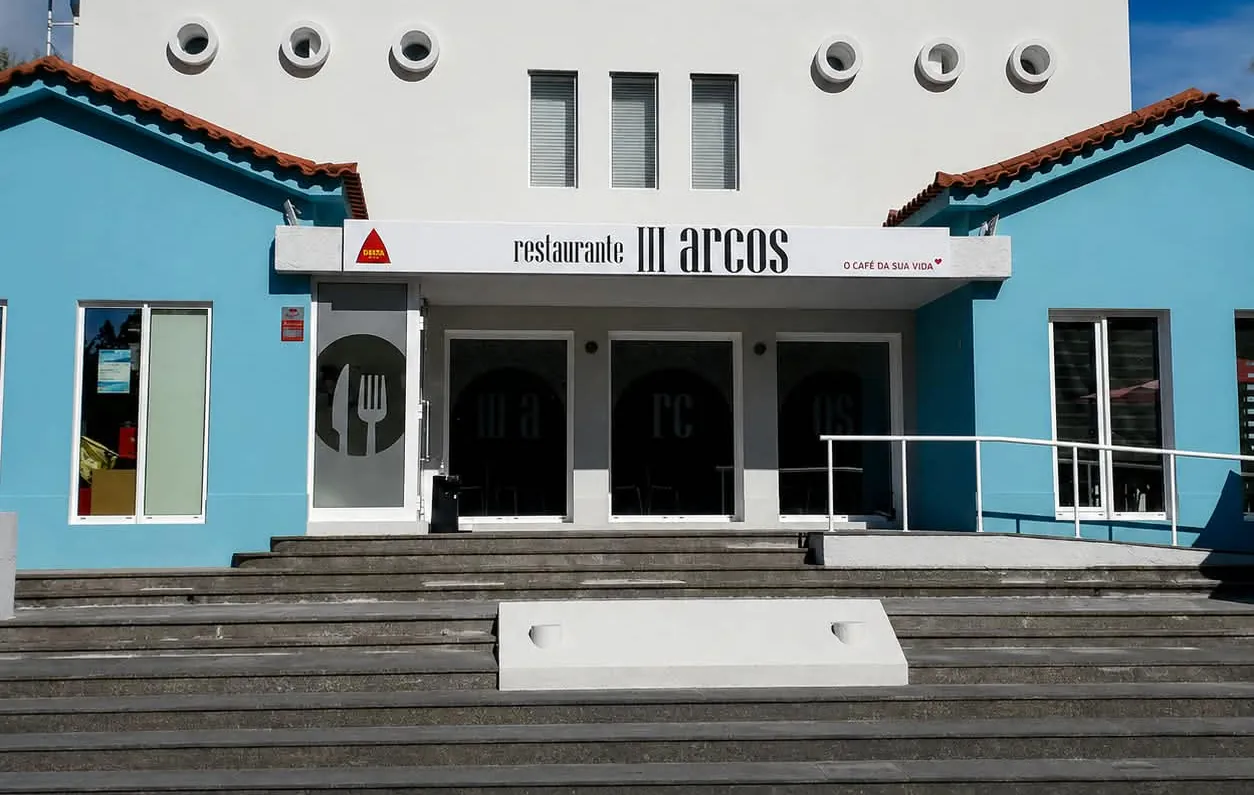 Fachada do Restaurante III Arcos, edifício branco e azul com escadaria