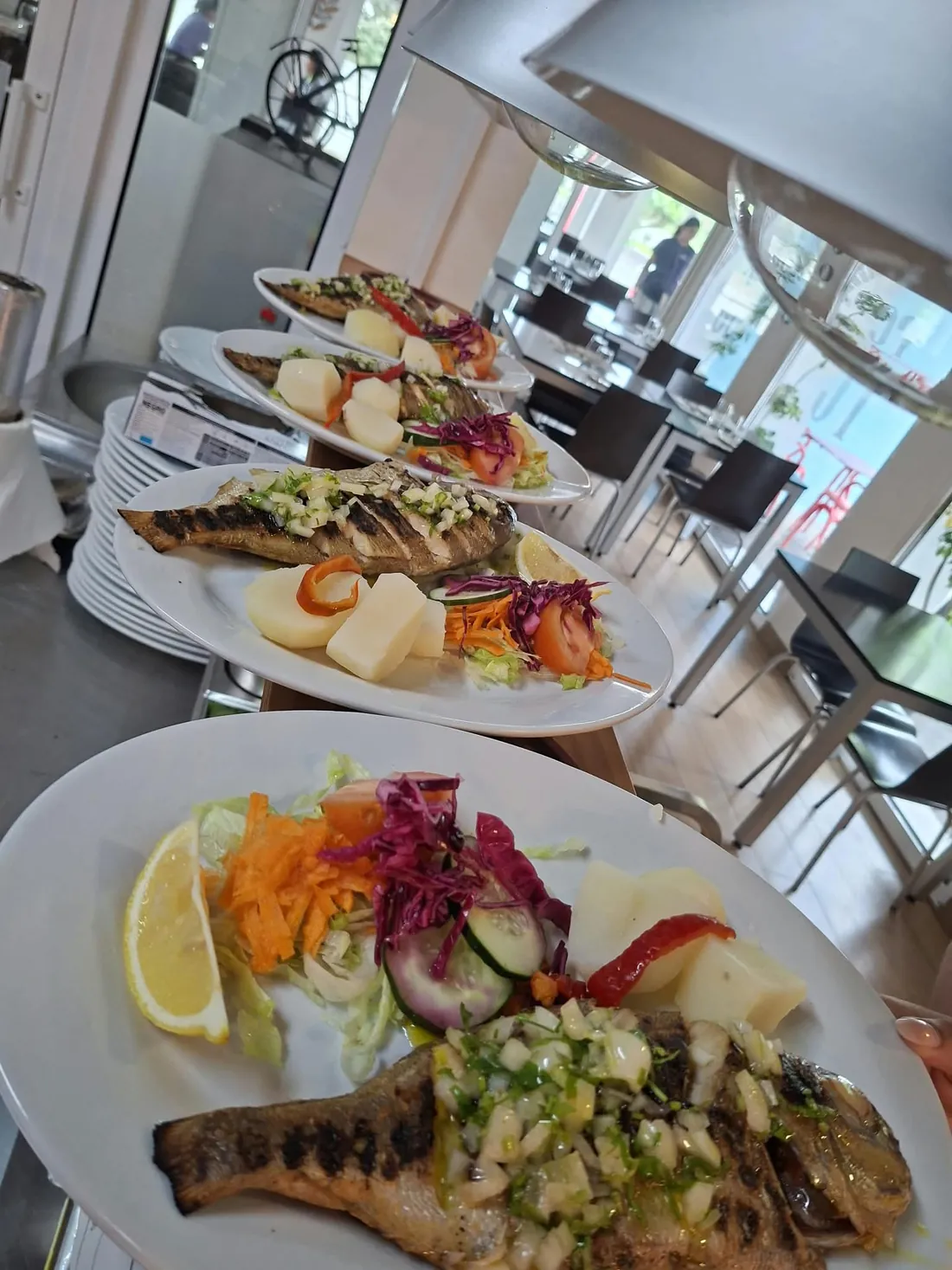 Pratos de peixe prontos a sair para a sala